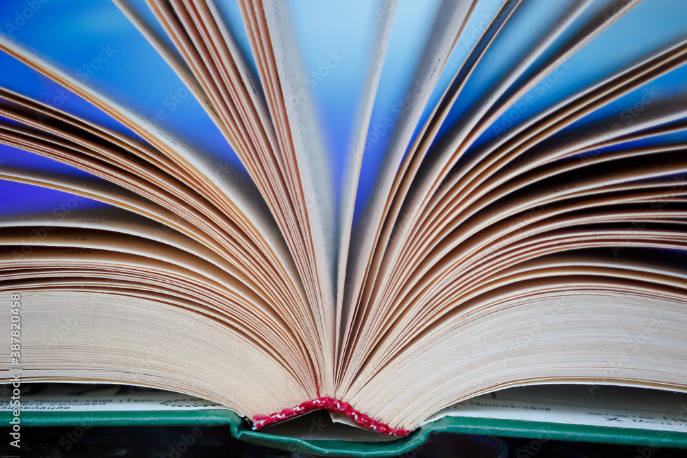 Fototapeta premium Pages of an unfolded book with a binding on a colorful background