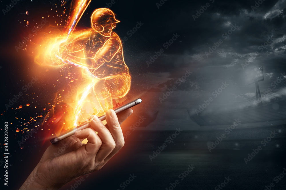 Fototapeta A silhouette, an image of a baseball player with a bat on fire crawls out of a smartphone, a hologram. Online sports concept, betting, American game.