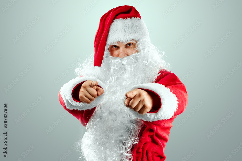 Portrait of Santa Claus in a red suit points his fingers, light background. Concept for christmas eve, vacation, holiday banner, new year. Portrait of Santa Claus in a red suit points his fingers, light background. Concept for christmas eve, vacation, holiday banner, new year.