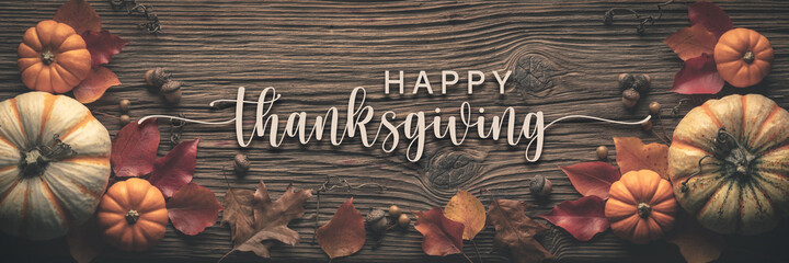 "Happy Thanksgiving" Message On Rustic Harvest Table Background Decorated With Pumpkins Acorns And Leaves 