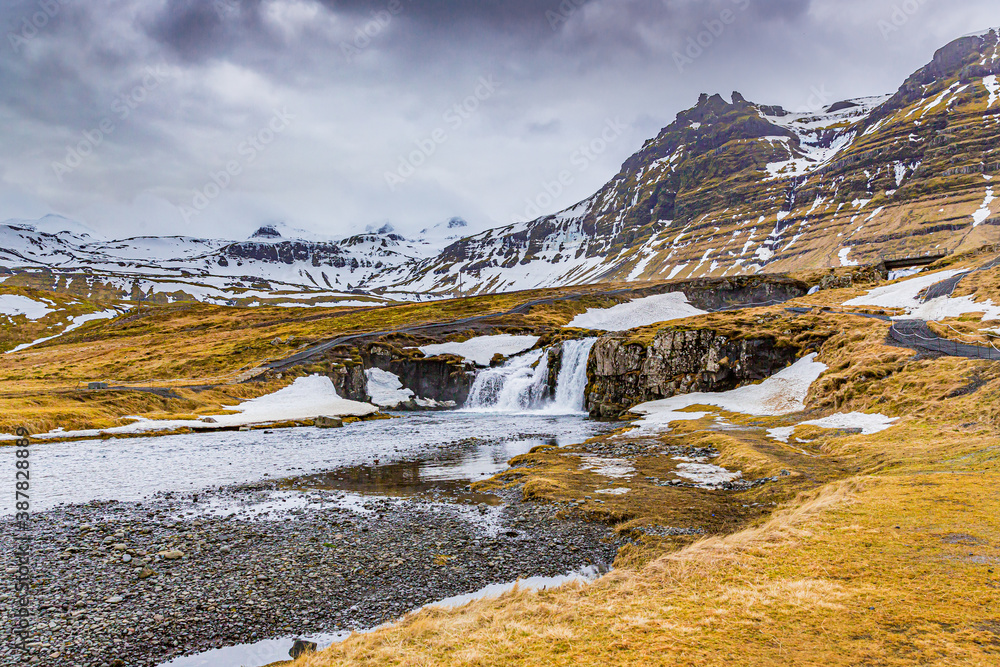 Stunning Kirkjufellsfoss waterfall during rare warming spell in winter