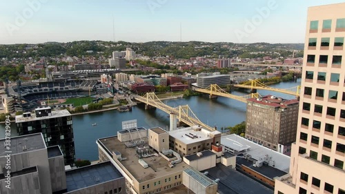 Aerial revealing shot of downtown Pittsburgh, to Allegheny River and city of bridges over Allegheny River during autumn magic hour. photo