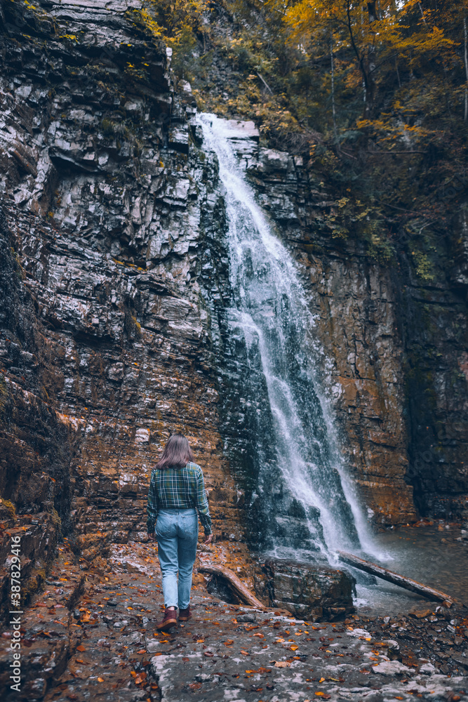 woman in casual clothes looking at waterfall