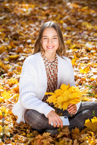 Blonde teenage girl posing in autumn park