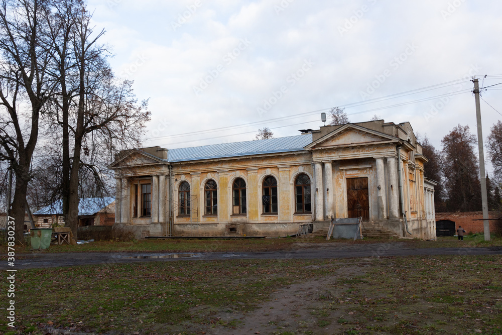 Old stone  building with columns in russian village on monastery backyard in autumn day