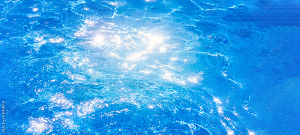 water in swimming pool background the surface of the water. texture, blue water, bright rays of the sun. web panorama banner with copy space. water in swimming pool background the surface of the water. texture, blue water, bright rays of the sun. web panorama banner with copy space.
