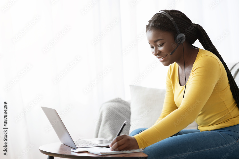 Distance Learning. Smiling African Female In Headset Studying With Laptop At Home Distance Learning. Smiling African Female In Headset Studying With Laptop At Home