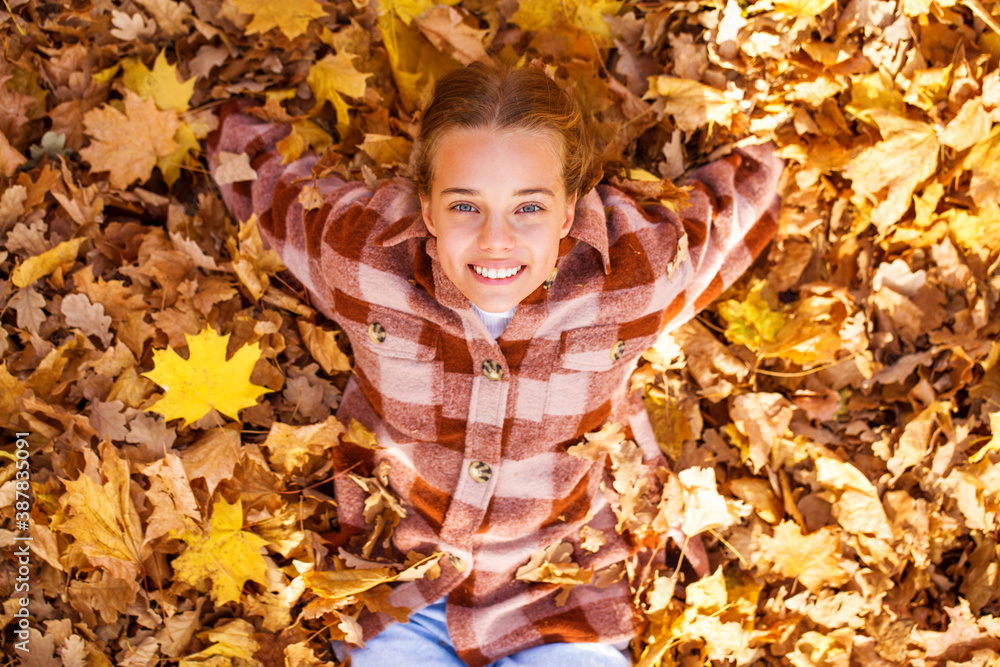 Portrait of young teenage girl lying in autumn foliage Portrait of young teenage girl lying in autumn foliage