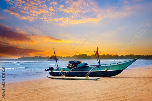 Against the background of the sunset sky and the ocean, an old fishing boat. Sri Lanka