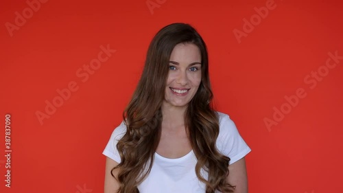 Shy woman in red studio isolated. Portrait of shame girl embarrassed smile. Shyness person expression. Shy model face. Doubt woman beautiful looking camera photo