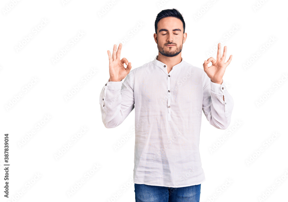 Young handsome man wearing casual clothes relax and smiling with eyes closed doing meditation gesture with fingers. yoga concept. Young handsome man wearing casual clothes relax and smiling with eyes closed doing meditation gesture with fingers. yoga concept.