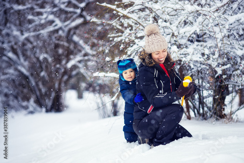 mother and little boy making snowballs