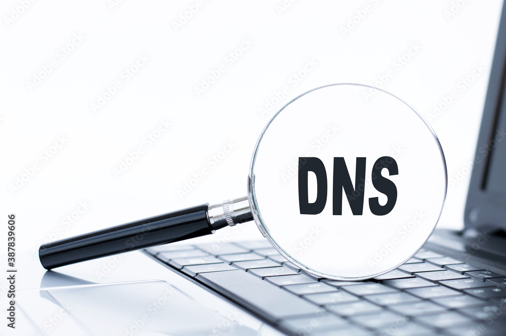 Focused on business concept. Magnifying glass with text dns on laptop keyboard. Business concept Focused on business concept. Magnifying glass with text dns on laptop keyboard. Business concept