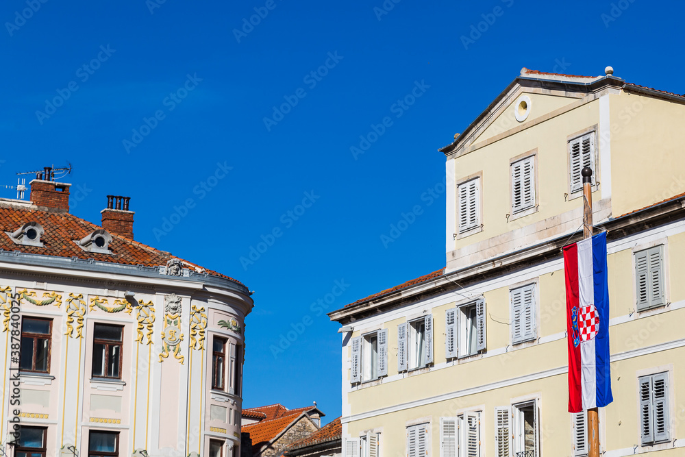 Croatian flag contrasts against old buildings