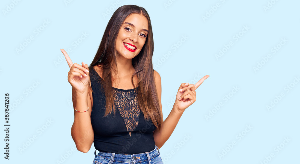Young hispanic woman wearing casual clothes smiling confident pointing with fingers to different directions. copy space for advertisement Young hispanic woman wearing casual clothes smiling confident pointing with fingers to different directions. copy space for advertisement