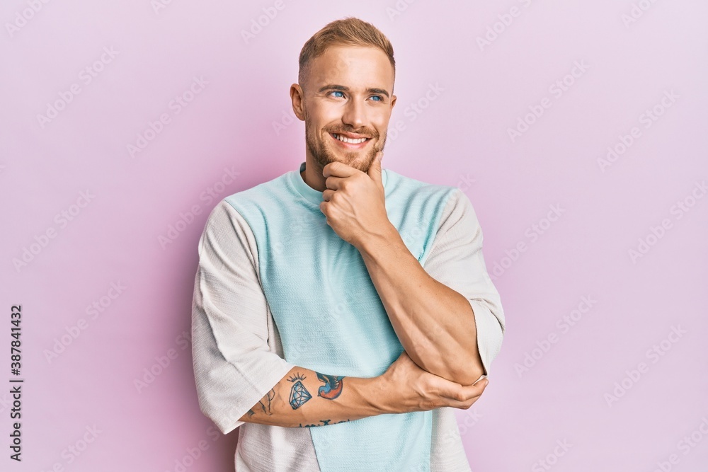 Young caucasian man wearing casual clothes with hand on chin thinking about question, pensive expression. smiling with thoughtful face. doubt concept. Young caucasian man wearing casual clothes with hand on chin thinking about question, pensive expression. smiling with thoughtful face. doubt concept.