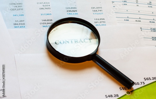 Magnifier on contract paper with financial statements. Home business diagram.