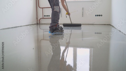 Filling the floor. A contractor painter will paint the garage floor to speed up the sale of your home. Fill in the low spots with self-leveling compound for a fine leveling. photo