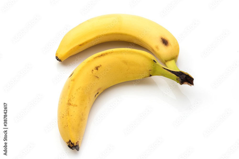 Bananas with some dark spots with shadow isolated on white background. Closeup, selective focus. Two old banana with spots, on a white isolated backgroun Bananas with some dark spots with shadow isolated on white background. Closeup, selective focus. Two old banana with spots, on a white isolated backgroun