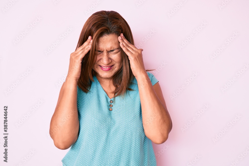 Middle age brunette hispanic woman wearing casual clothes with hand on head for pain in head because stress. suffering migraine. Middle age brunette hispanic woman wearing casual clothes with hand on head for pain in head because stress. suffering migraine.