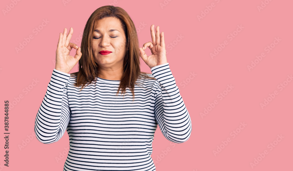 Middle age latin woman wearing casual clothes relax and smiling with eyes closed doing meditation gesture with fingers. yoga concept. Middle age latin woman wearing casual clothes relax and smiling with eyes closed doing meditation gesture with fingers. yoga concept.