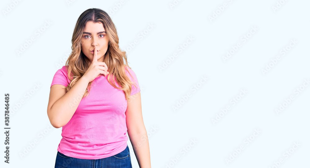 Young caucasian woman wearing sportswear asking to be quiet with finger on lips. silence and secret concept. Young caucasian woman wearing sportswear asking to be quiet with finger on lips. silence and secret concept.