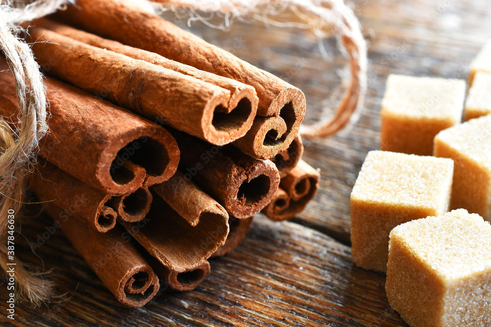 A close up image of fresh cinnamon sticks and brown sugar cubes.  - obrazy, fototapety, plakaty 