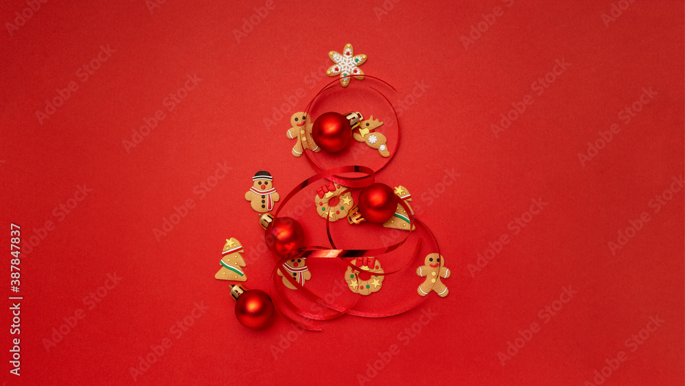 Christmas tree made with Christmas cookies and Christmas balls on red background