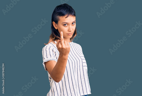 Young woman wearing casual clothes showing middle finger, impolite and rude fuck off expression