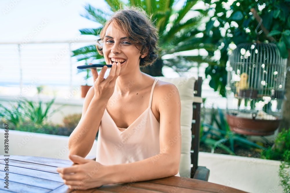 Young beautiful caucasian woman smiling happy at home sending a voice message using smartphone Young beautiful caucasian woman smiling happy at home sending a voice message using smartphone