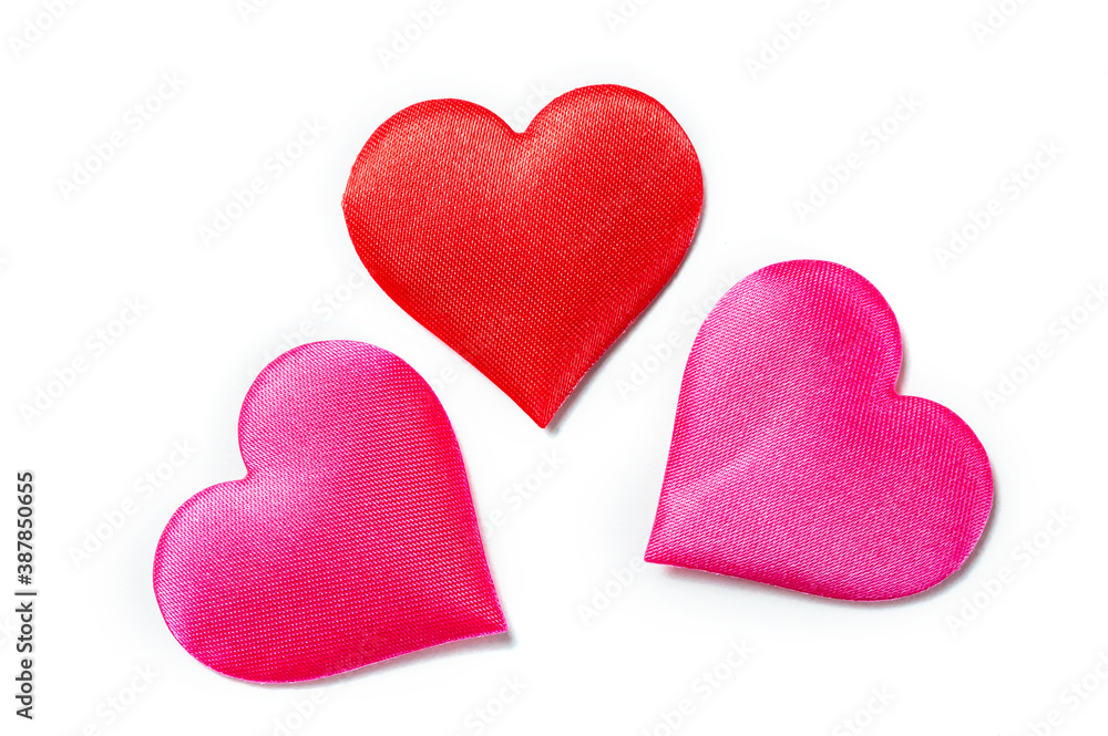 three textile hearts in red and pink fabric on a white background three textile hearts in red and pink fabric on a white background