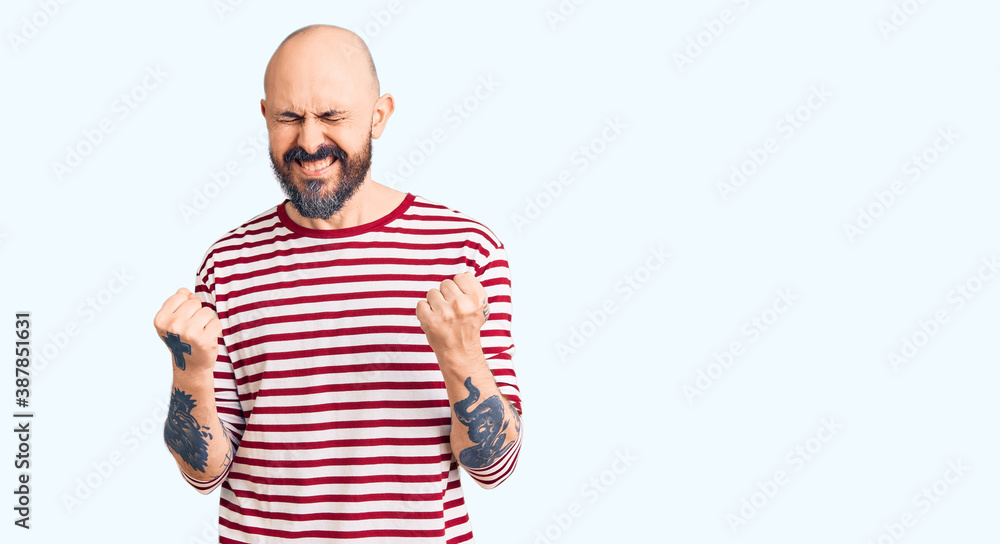 Young handsome man wearing casual clothes very happy and excited doing winner gesture with arms raised, smiling and screaming for success. celebration concept. Young handsome man wearing casual clothes very happy and excited doing winner gesture with arms raised, smiling and screaming for success. celebration concept.