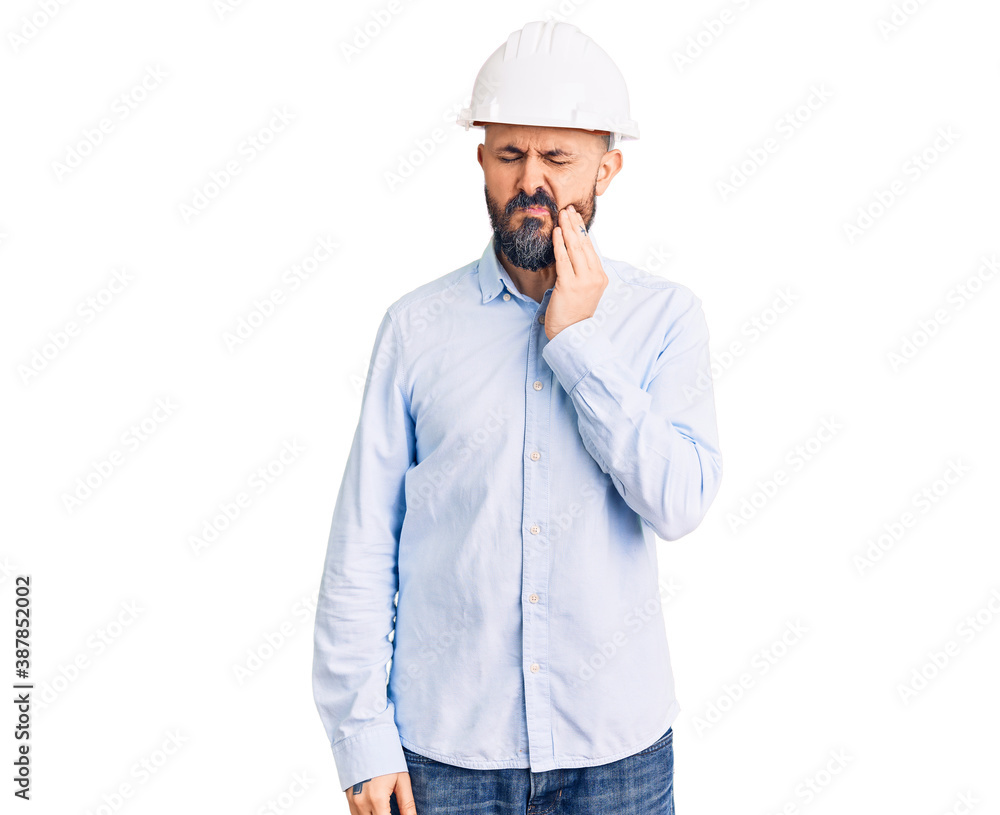 Young handsome man wearing architect hardhat touching mouth with hand with painful expression because of toothache or dental illness on teeth. dentist Young handsome man wearing architect hardhat touching mouth with hand with painful expression because of toothache or dental illness on teeth. dentist