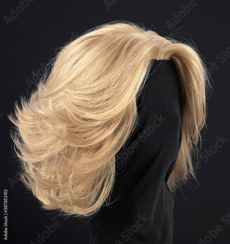 Long wavy blonde hair wig, side view, black background