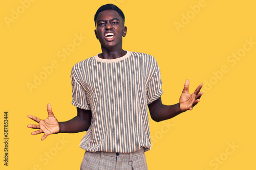 Young african american man wearing casual clothes gesturing with hands showing big and large size sign, measure symbol. smiling looking at the camera. measuring concept.