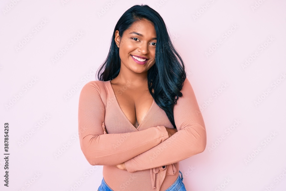 Beautiful latin young woman with long hair wearing casual clothes happy face smiling with crossed arms looking at the camera. positive person. Beautiful latin young woman with long hair wearing casual clothes happy face smiling with crossed arms looking at the camera. positive person.