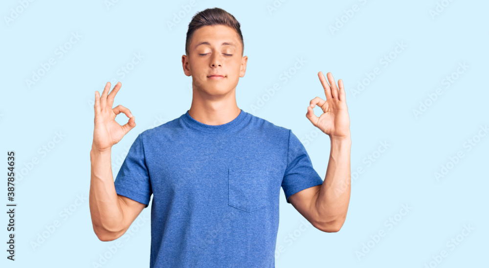 Fototapeta premium Young handsome hispanic man wearing casual clothes relax and smiling with eyes closed doing meditation gesture with fingers. yoga concept.