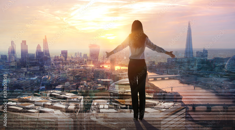 Fototapeta premium Young woman looking at city of London at sunset. River Thames, embankment, business area of the City. London, UK
