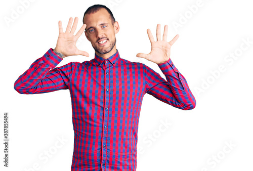 Young handsome man wearing casual clothes showing and pointing up with fingers number ten while smiling confident and happy.