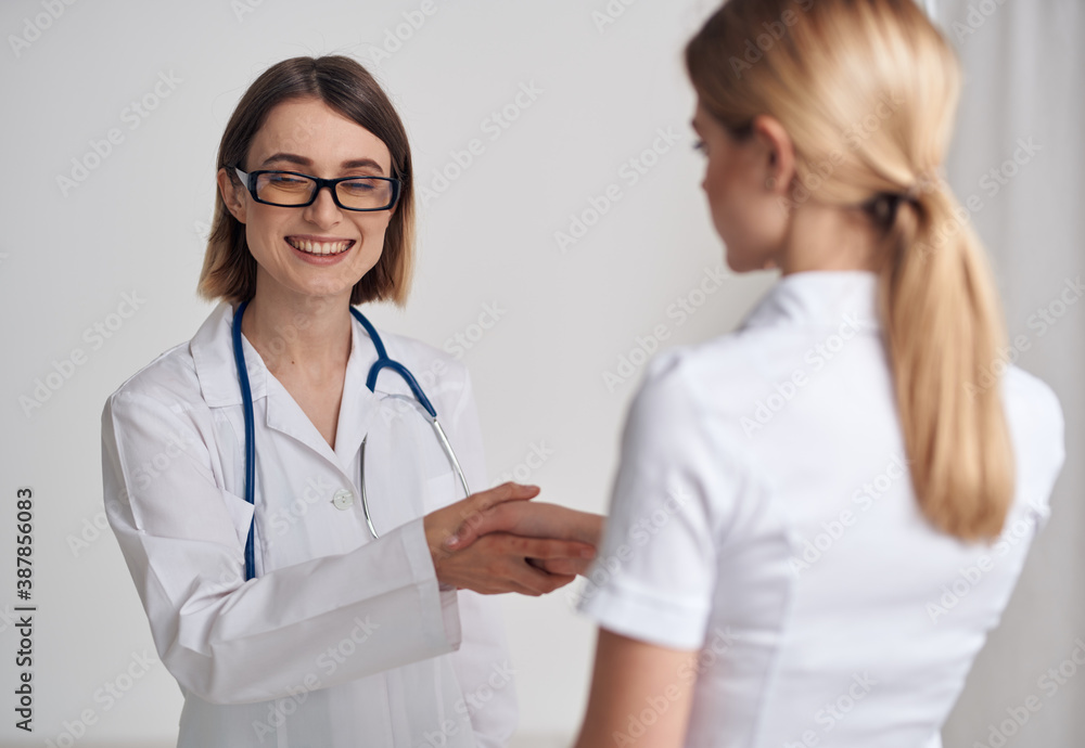 doctor and patient shaking hands on a light background stethoscope around the neck doctor and patient shaking hands on a light background stethoscope around the neck
