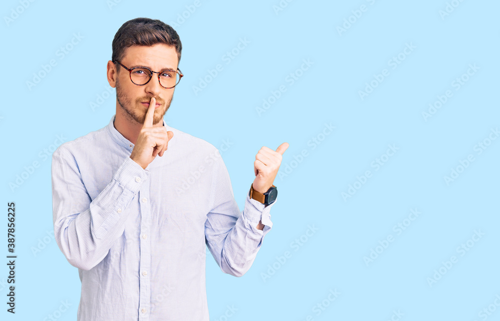 Handsome young man with bear wearing elegant business shirt and glasses asking to be quiet with finger on lips pointing with hand to the side. silence and secret concept. Handsome young man with bear wearing elegant business shirt and glasses asking to be quiet with finger on lips pointing with hand to the side. silence and secret concept.