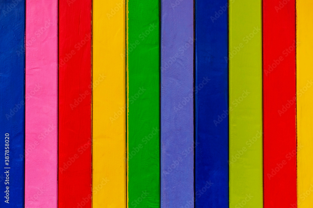 Background from wooden colored bright boards with copy space. Wall surface made of vertical boards of different colors. Colorful Wood Background Background from wooden colored bright boards with copy space. Wall surface made of vertical boards of different colors. Colorful Wood Background