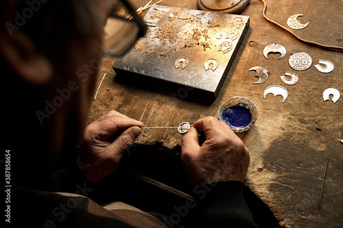 Hand-made silver items with cloisonné enamel in progress. Traditional work in the mountain village of Kubachi, Dagestan. photo