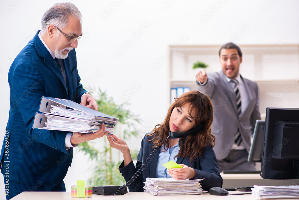 Fototapeta premium Two male and one female employees working in the office
