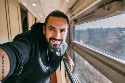 A man takes a selfie at the train window