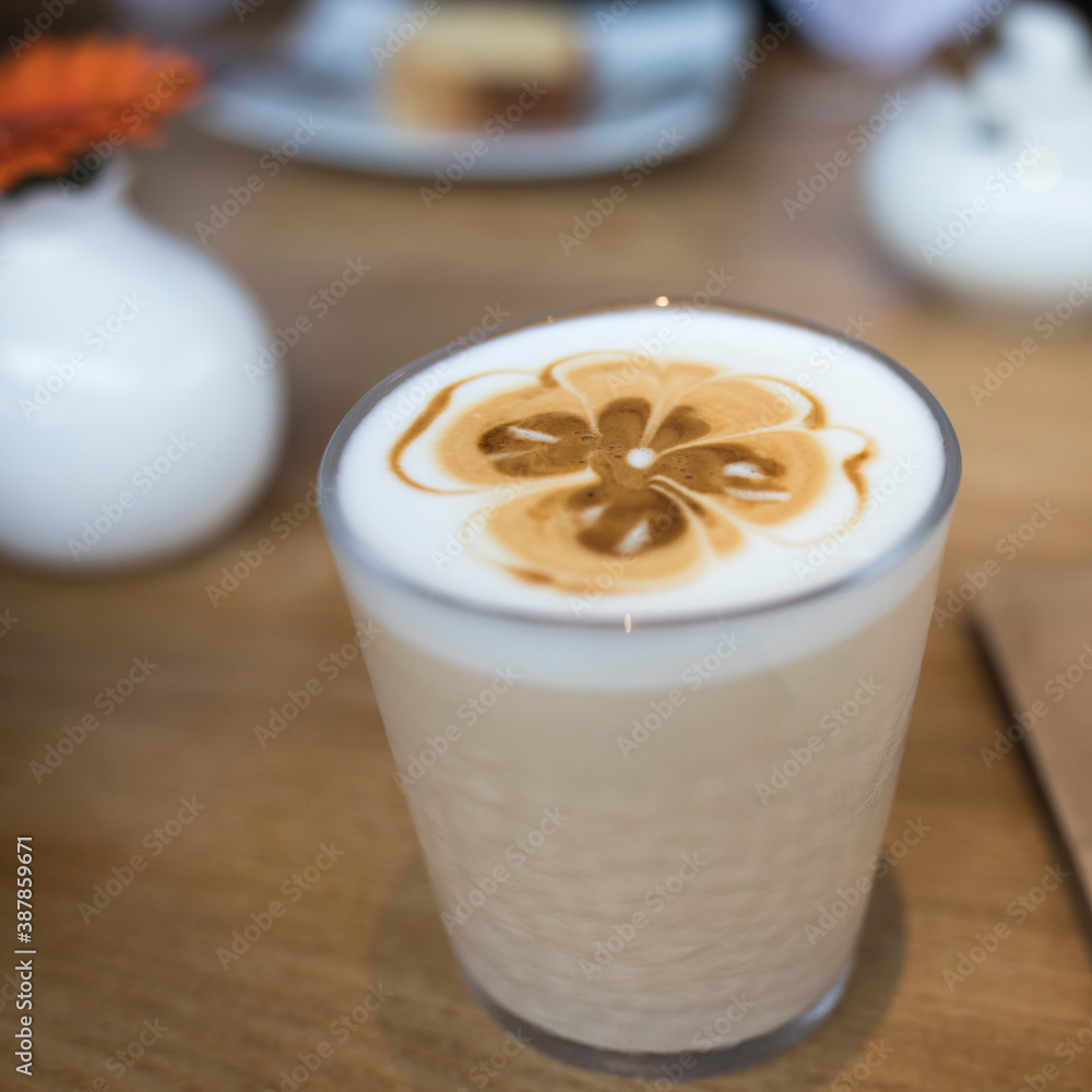 Big transparent coffee glasses with heart shape latte art foam on black wood table near window Big transparent coffee glasses with heart shape latte art foam on black wood table near window