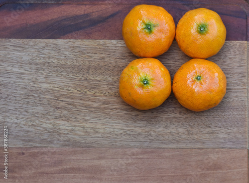 fresh tangerines on the edge of wooden background. top view. Whith space to copy