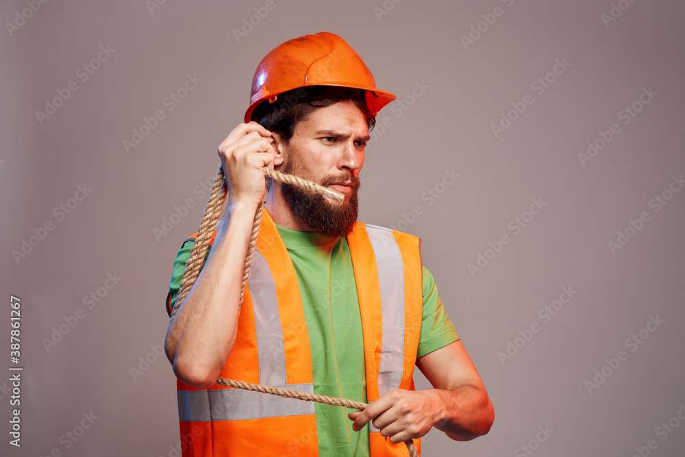 Man in construction uniform orange hard hat cropped view over beige background Man in construction uniform orange hard hat cropped view over beige background