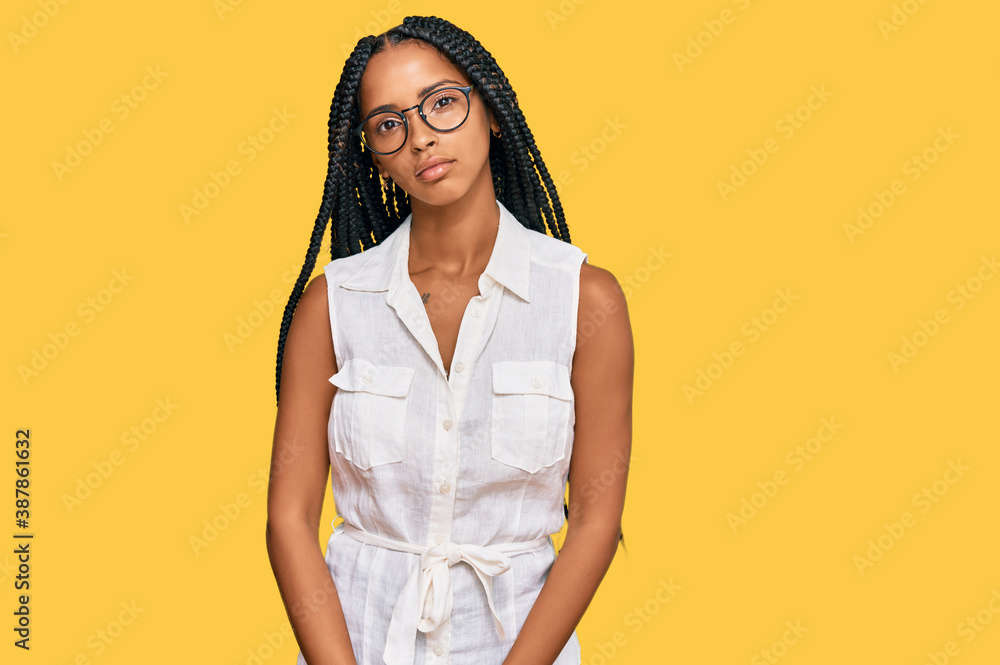 Obraz premium Beautiful hispanic woman wearing casual clothes and glasses relaxed with serious expression on face. simple and natural looking at the camera.