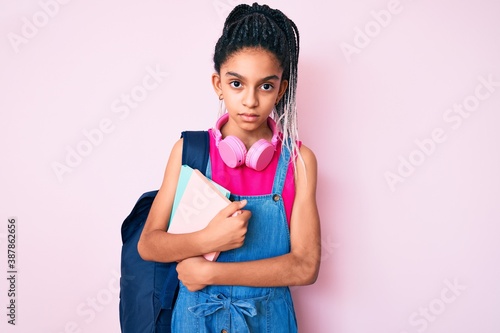 Obraz na plátně Young african american girl child with braids holding student backpack and books
